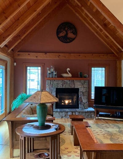 Cozy sitting room with stone fireplace and timber frame accents