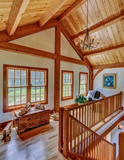 Loft at the top of the staircase with toy chest and wooden trucks