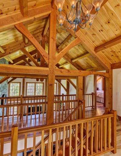 View from loft across timber frame trusses and cathedral ceiling of the Great Room.