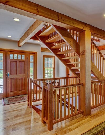 Front door with wooden staircase and timber frame accents