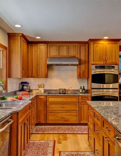 Kitchen with wooden cabinets, stainless steel appliances, and hanging lamps