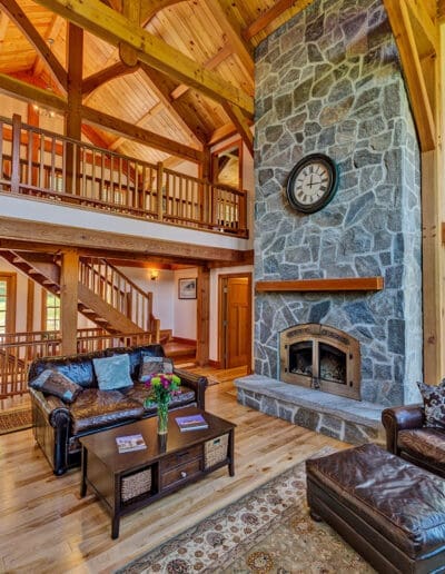 Great room featuring timber frame cathedral ceilings and stone fireplace