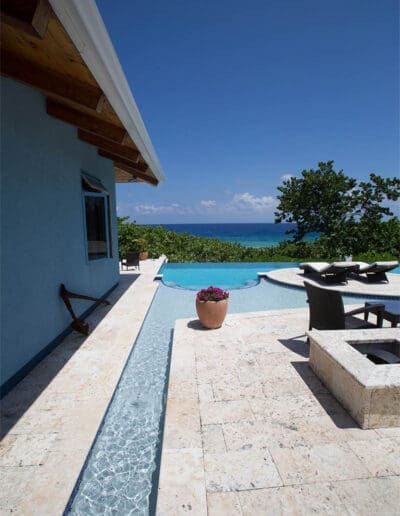 Infinity pool by the Caribbean Timber Frame with the ocean beyond.