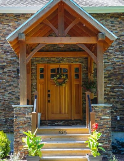 Front door with small entry porch featuring timber frame accents.