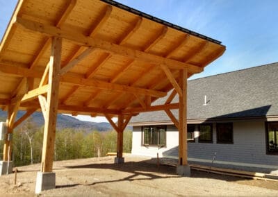 Timber frame holding solar panel next to barn