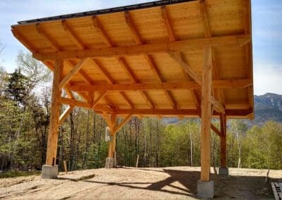 Timber frame holding solar panel next to barn