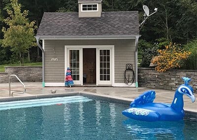 View of pool cabana next to pool and