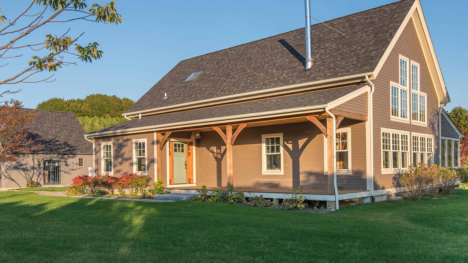 Front exterior view of the Custom Classic Homestead with a simple front porch with timber frame elements.